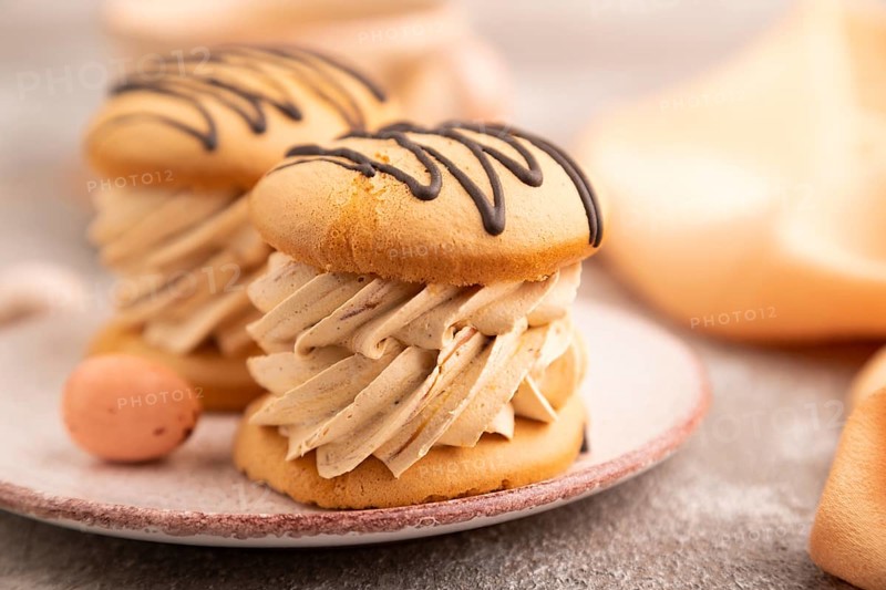 Caramel Cream Cakes on brown concrete background, cup of coffee, side view, close up, selective focus