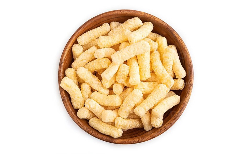 Corn flakes sticks with caramel in wooden bowl isolated on white background. top view, flat lay, close up