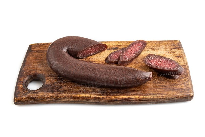 Sujuk sausage isolated on wooden cutting board on white background. Side view, copy space