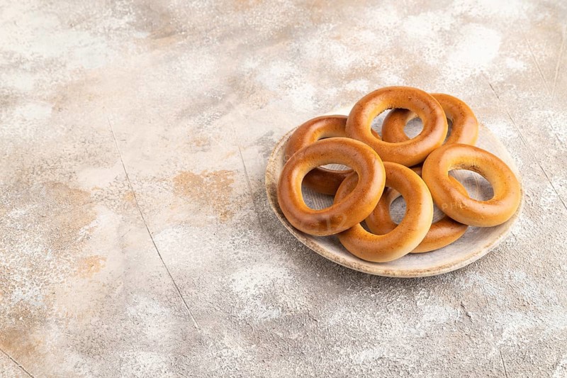 Homemade Ring Bagel on brown concrete background. side view, copy space