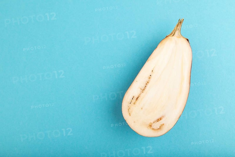 Purple Cutted eggplant on blue pastel background. Top view, flat lay, copy space. Tropical, healthy food, vegetable, slice, minimalism