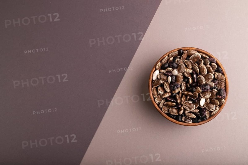 Wooden bowl with Kidney beans on beige and gray pastel paper background, top view, flat lay, copy space, minimalism