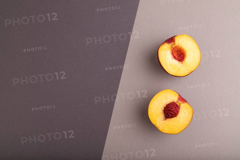 Peach Cut in half on black and gray paper pastel background. Top view, flat lay, copy space. healthy food, minimalism