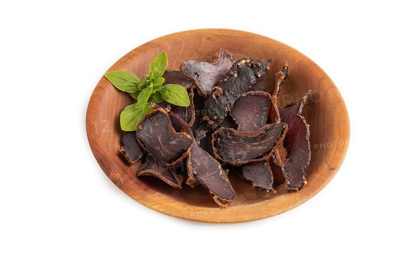 Armenian Basturma dried meat on wooden bowl isolated on white background. Side view