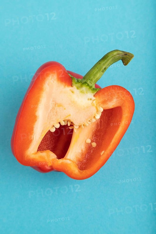 Red Cutted pepper on blue pastel background. Top view, flat lay, copy space. Tropical, healthy food, vegetable, slice, minimalism