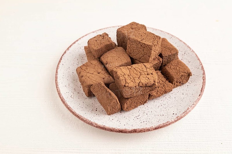 Chocolate marshmallow on white wooden background. side view, close up