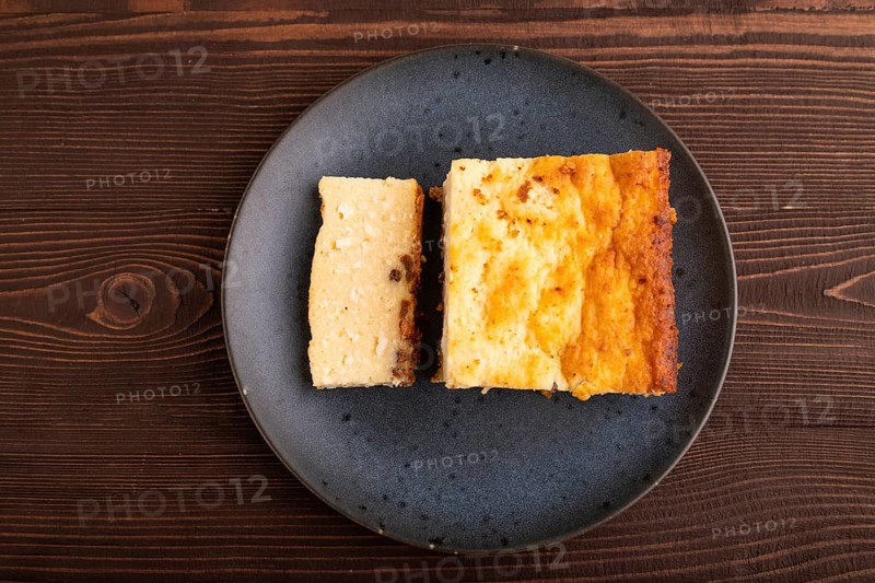 ?ottage cheese ?asserole, Curd cake, with dried apricots and raisins on brown wooden background, top view, flat lay, copy space, minimalism