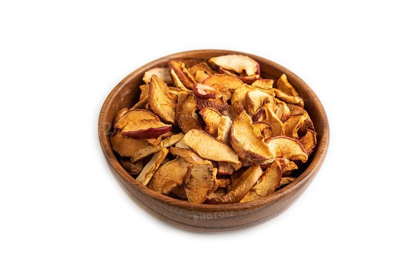 Dried Apples in wooden bowl isolated on white background. Side view, close up, healthy food, minimalism. sweet