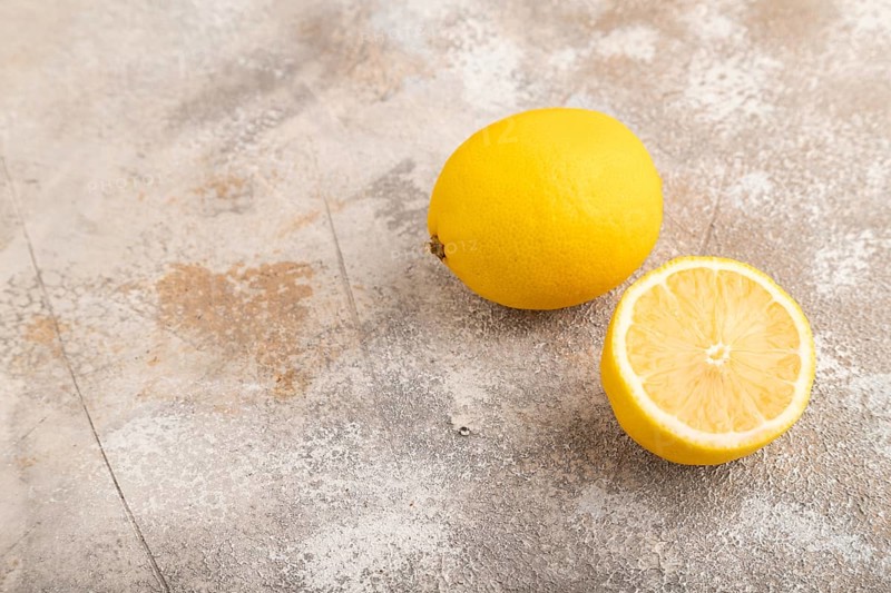 Yellow Lemon Cut in half on brown concrete background. Side view, copy space. healthy food, vegetable, minimalism. citrus