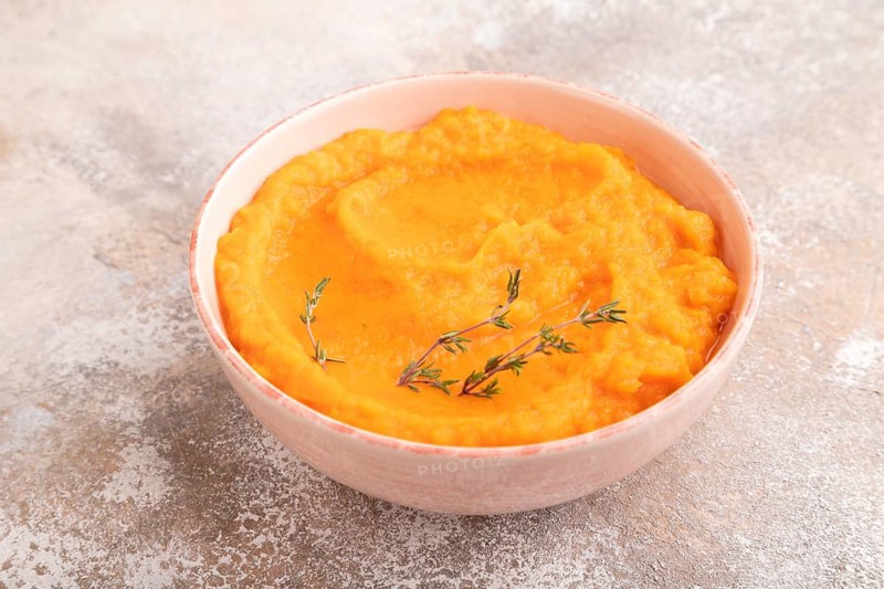 Sweet potato porridge in ceramic bowl on brown concrete background. Diet, healthy eating concept. side view, copy space