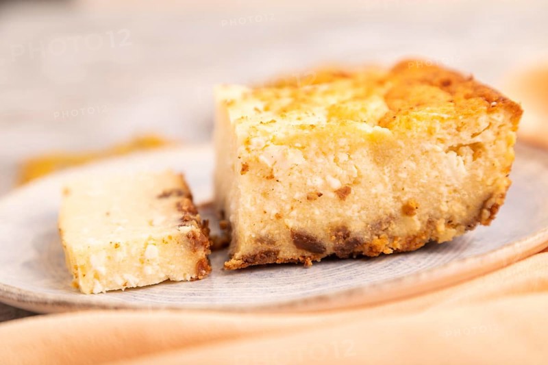 ?ottage cheese ?asserole, Curd cake, with dried apricots and raisins on brown concrete background and orange textile, side view, selective focus, minimalism