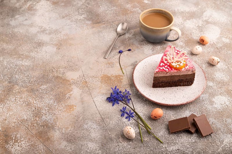 Chocolate cake on brown concrete background, cup of coffee, side view, copy space