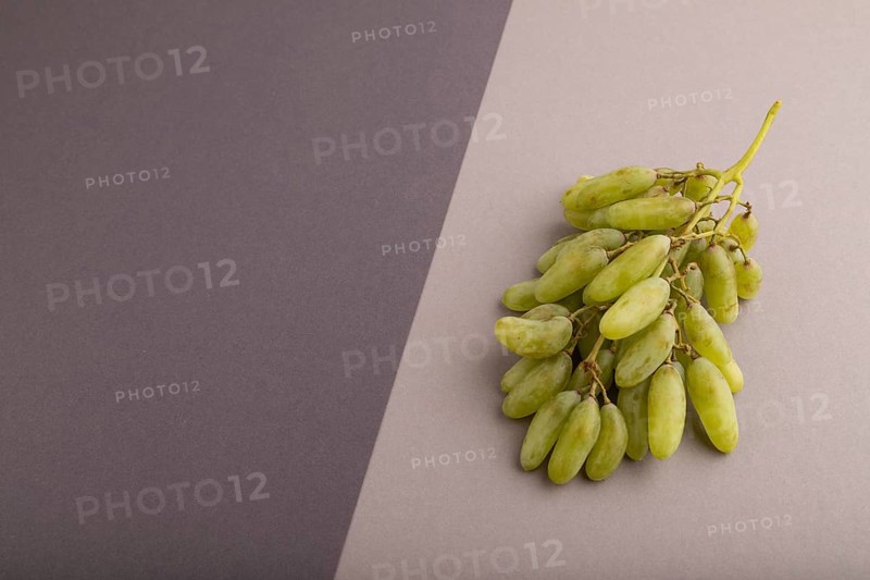Green grapes on gray and black paper pastel background. Side view, copy space. healthy food, minimalism