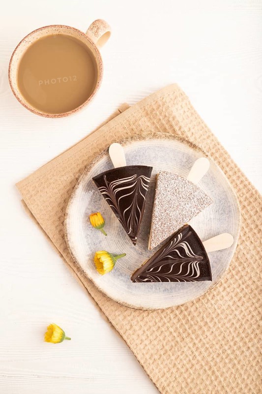 Chocolate and Vanilla Cake pops Marshmallow with cup of coffee on white wooden background and beige linen textile. top view, flat lay, close up