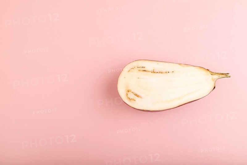 Purple Cutted eggplant with white stripes on pink pastel background. Top view, flat lay, copy space. Tropical, healthy food, vegetable, slice, minimalism