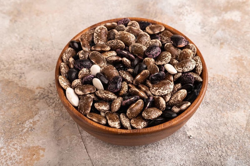 Wooden bowl with Kidney beans on brown concrete background, side view, close up, minimalism