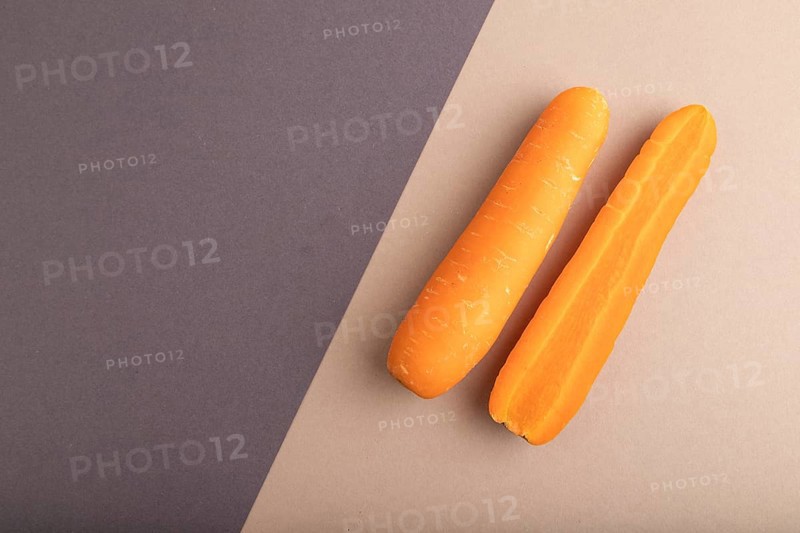 Orange Carrot on beige and gray pastel paper background. Top view, copy space, flat lay. healthy food, vegetable, minimalism