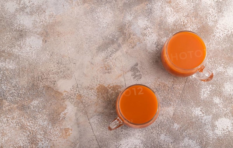 Two glasses with carrot juice, on brown concrete background. Diet, healthy eating concept. top view, flat lay, copy space, minimalism