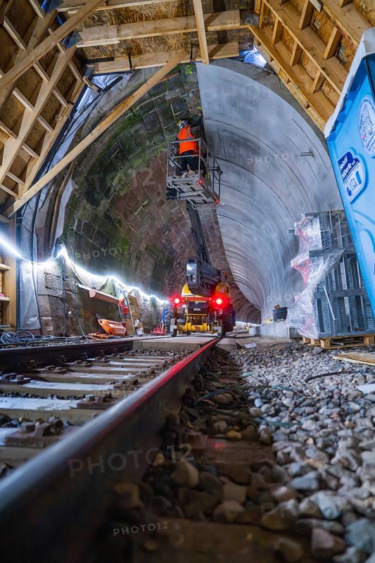 Tunnelbau mit Schienen, Maschinen, beleuchteter Atmosphäre und einem Bauarbeiter in Aktion, Bau der Hermann Hessenahn, Calw, Schwarzwald, Deutschland