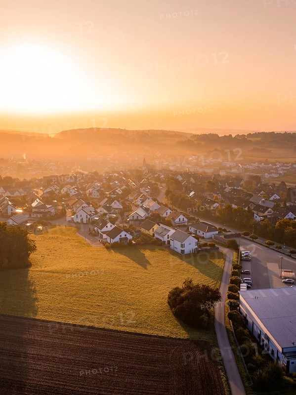 Dorfansicht bei Sonnenaufgang mit beleuchteten Dächern und umliegenden Feldern, Gechingen, Heckengäu, Landkreis Calw, Deutschland