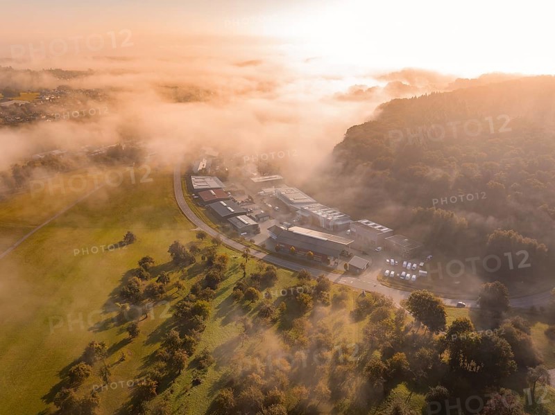 Nebel und Morgensonne schaffen eine atmosphärische Landschaft über Industriegebäuden, Gechingen, Heckengäu, Landkreis Calw, Deutschland