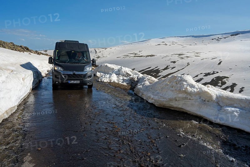Van auf schmelzender Straße zwischen hohen Schneewänden in bergiger Umgebung, mit dem Camper zum Aragaz, Aragats, Aragac, Alagyaz, erloschener Schichtvulkan, 4090 m, Aragazotn, Schirak, Armenien