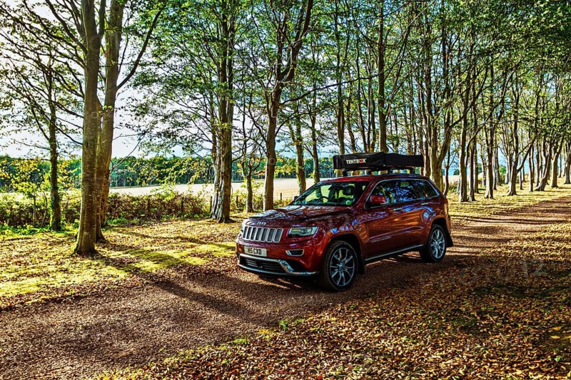4x4 car with roof tent on autumn forest road, Tyninghame House, River Tyne, East Lothian, Scotland, UK