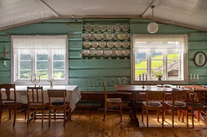 Esszimmer mit Holztischen, Holzstühlen und Tellern in einem Regal, historischer Bauernhof und Pilgerunterkunft Budsjord, Dovre, Pilgerweg Olavsweg oder Olavsleden, Gudbrandsdalen oder Gudbrandstal, Norwegen