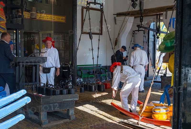 Männer mit roten Hüten bereiten Käse auf einem traditionellen Markt vor, ehemalige Stadtwaage, Käse wiegen, Käseträger, Käse, Käsemarkt, Alkmaar, Alkmar, Noord-Holland, Nordholland, Niederlande