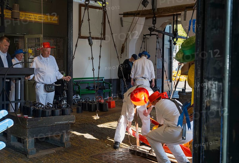 Männer in weiß mit roten Hüten bei der Arbeit auf einem Käsemarkt, ehemalige Stadtwaage, Käse wiegen, Käseträger, Käse, Käsemarkt, Alkmaar, Alkmar, Noord-Holland, Nordholland, Niederlande