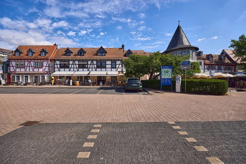 Historische Fachwerkhäuser, Häuserzeile, Spitzdächer mit roten Dachpfannen, Gauben, Turm, Platz, Parkplatz Untertor, Auto, Bäume, Hecke, blauer Himmel, Cumuluswolken, Cirrostratuswolken, Platz am Untertor, Burggrabenstraße, Hofheim am Taunus, Main-Taunus-Kreis, Hessen, Deutschland