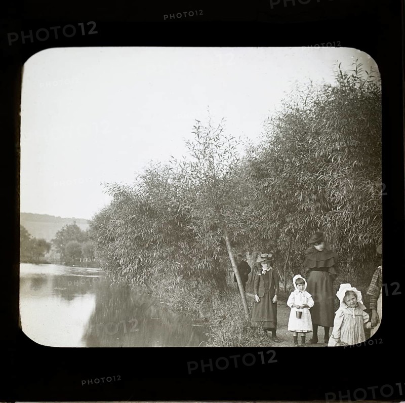 Magic lanterns slide of Edwardian children walking on a footpath next to a river, England, UK c 1900