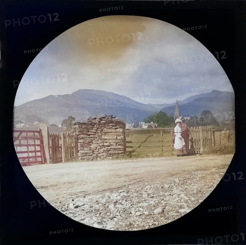 Woman Victorian or Edwardian tourist with background of Ambleside, Lake District, Cumbria, England, UK c 1900