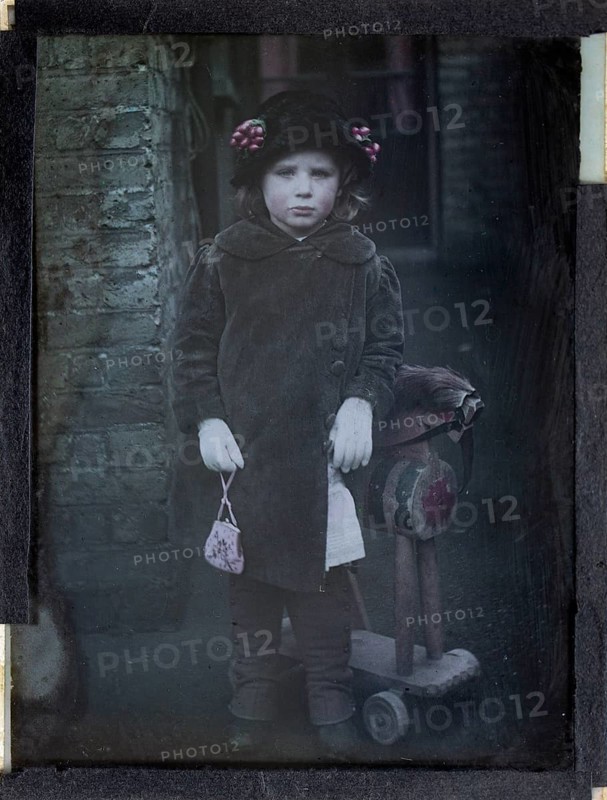 Paget process colourised magic lantern slide portrait of a young girl dressed up in adult clothing, circa 1900