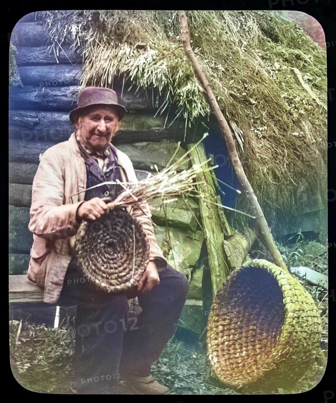 Portrait of elderly countryman weaving straw baskets in England, c 1890s-1900