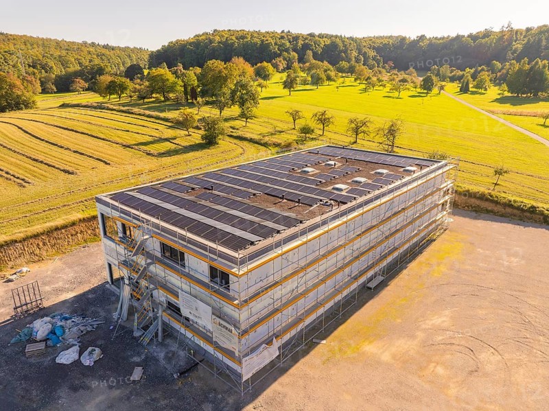 Modern building with solar panels surrounded by fields and forests, under construction, new build with green roof and PV system, Wiernsheim, Germany