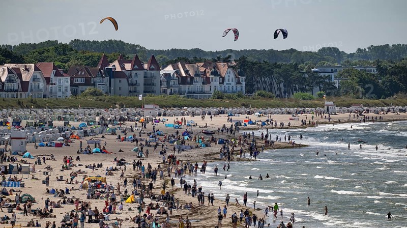 Kitesurfers float along a lively beach, surf, Warnemünde, Rostock, Mecklenburg-Vorpommern, Germany