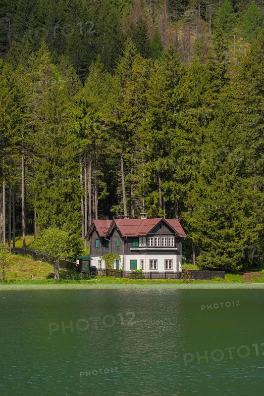 View over Lake Toblach to a house standing directly on the shore, Toblach, Höhlensteintal, South Tyrol, Italy