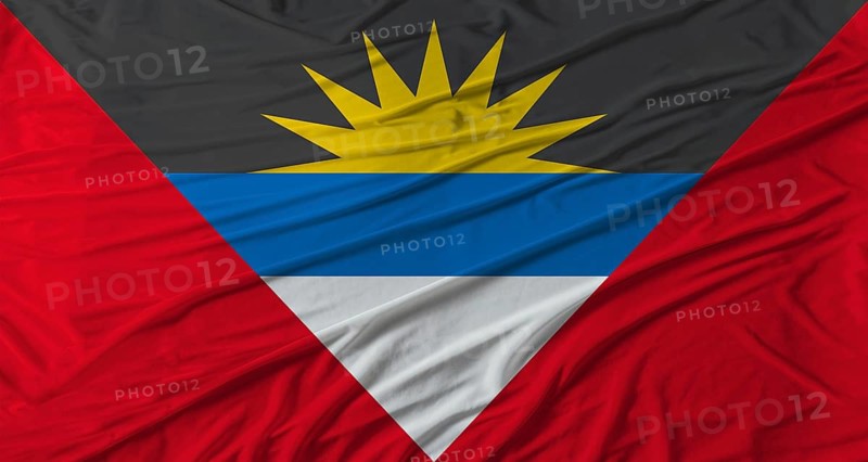Antiguan flag waving. Flag of Antigua and Barbuda with cloth texture