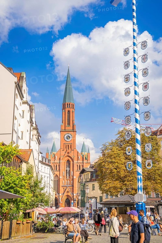 A lively city centre with a high church tower and a maypole, Munich, Germany