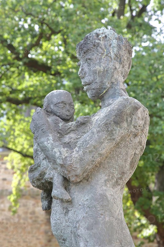 Sculpture Mother and Child by Sabine Grzimek 1981, bronze sculpture, life-size, modern art, standing female figure carrying infant in her arms, infant, protect, relationship, care, detail, sculpture park, Magdeburg, Saxony-Anhalt, Germany