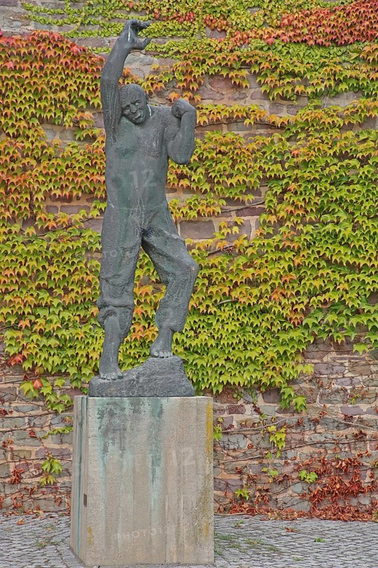 Sculpture Ascending man by Fritz Cremer 1967, rising man figure, arms, up, gesture, upwards, climb, move, rise, bronze sculpture, modern art, life-size, wall, ivy, vines, autumn, sculpture park, Magdeburg, Saxony-Anhalt, Germany