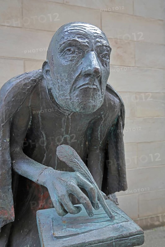 Albertus Magnus by Heinrich Apel 1985, medieval scholar and bishop writing with quill, bronze sculpture, monument, face, head, nose, look, look, see, frontal, perspective, Magnus monument, St. Petri, Magdeburg, Saxony-Anhalt, Germany