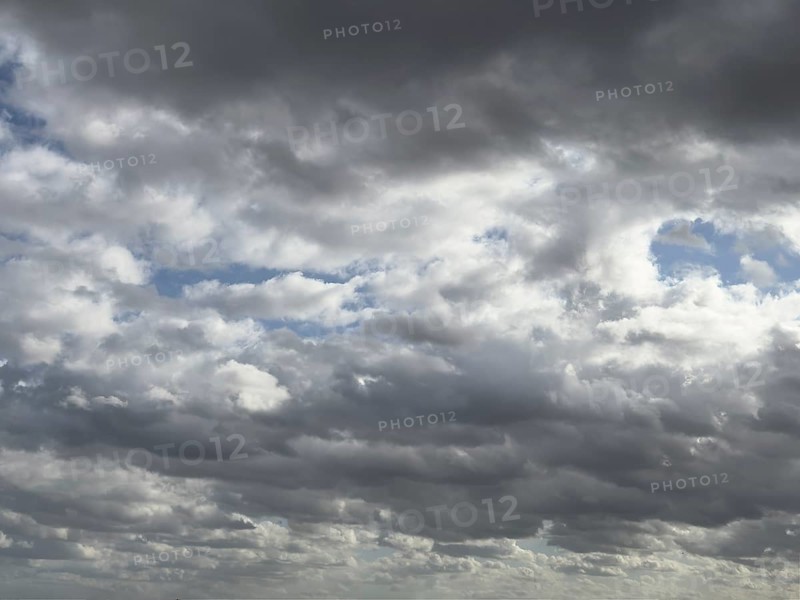 Heavily overcast sky with dark nimbostratus clouds rain clouds at the top and bottom of the picture, stratocumulus clouds in the background above, internationalNimbostratus clouds rain clouds, international