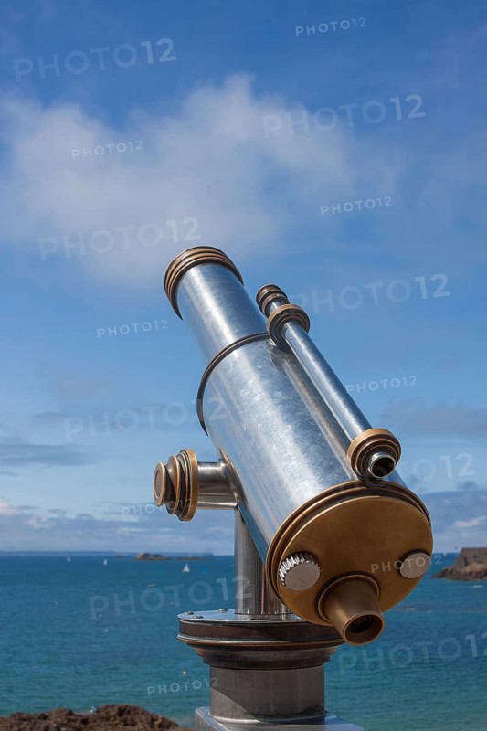 Binoculars point to the vast blue sea under a clear sunny sky, Saint Malo, Brittany, France