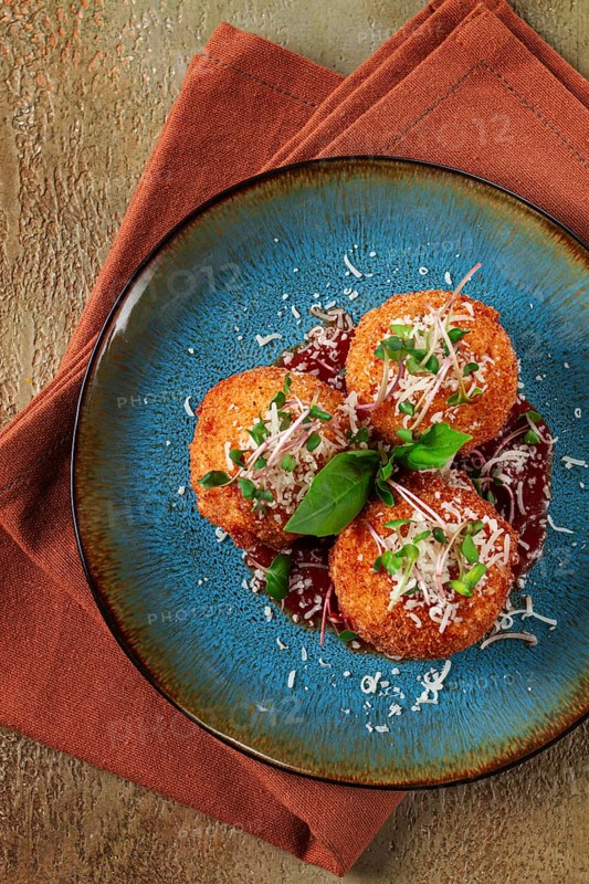Crispy Arancini appetizer, with parmesan cheese and microgreens, plate, tomato sauce, homemade, no people