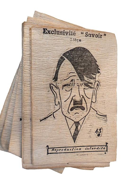 Close-up of 1943 vintage Belgian World War Two sheets of toilet paper with WW2 portrait of Adolf Hitler against white background