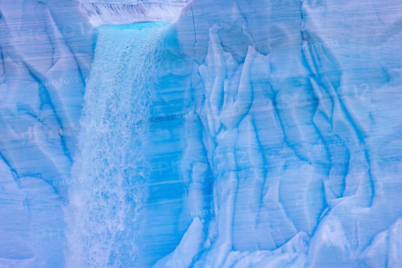 Waterfall at edge of the Brasvellbreen glacier from the ice cap Austfonna pouring into the Barents Sea, Nordaustlandet, Svalbard, Spitsbergen