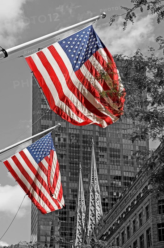 Waving USA flags, behind towers of St Patrick's Cathedral, Manhattan, New York City, USA