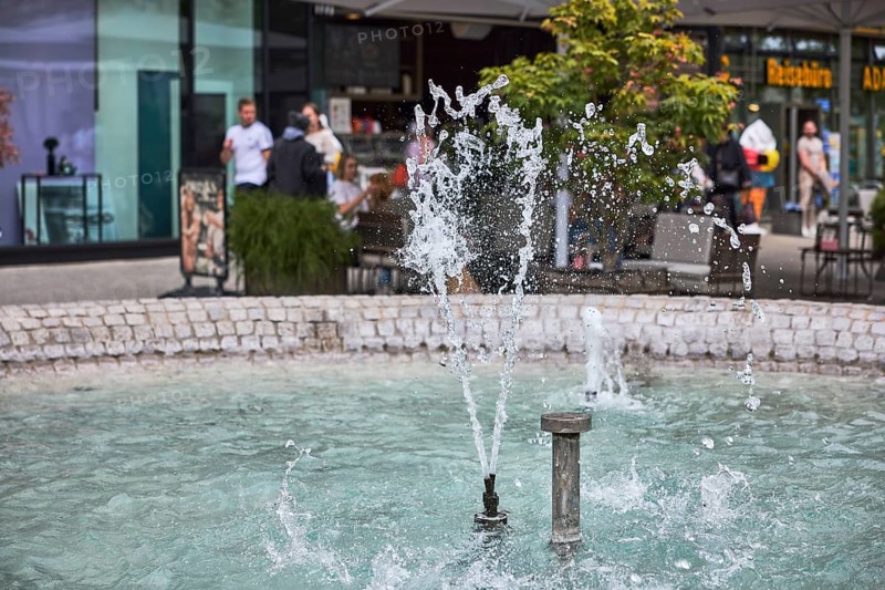 Cobblestone fountain, fountain, water, frozen movement, general architecture, pedestrian zone, shop window, outdoor area of a restaurant, pedestrians as accessories, depth of field, Kronprinzstraße, Büchsenstraße, Stuttgart, state capital, city district of Stuttgart, Baden-Württemberg, Germany